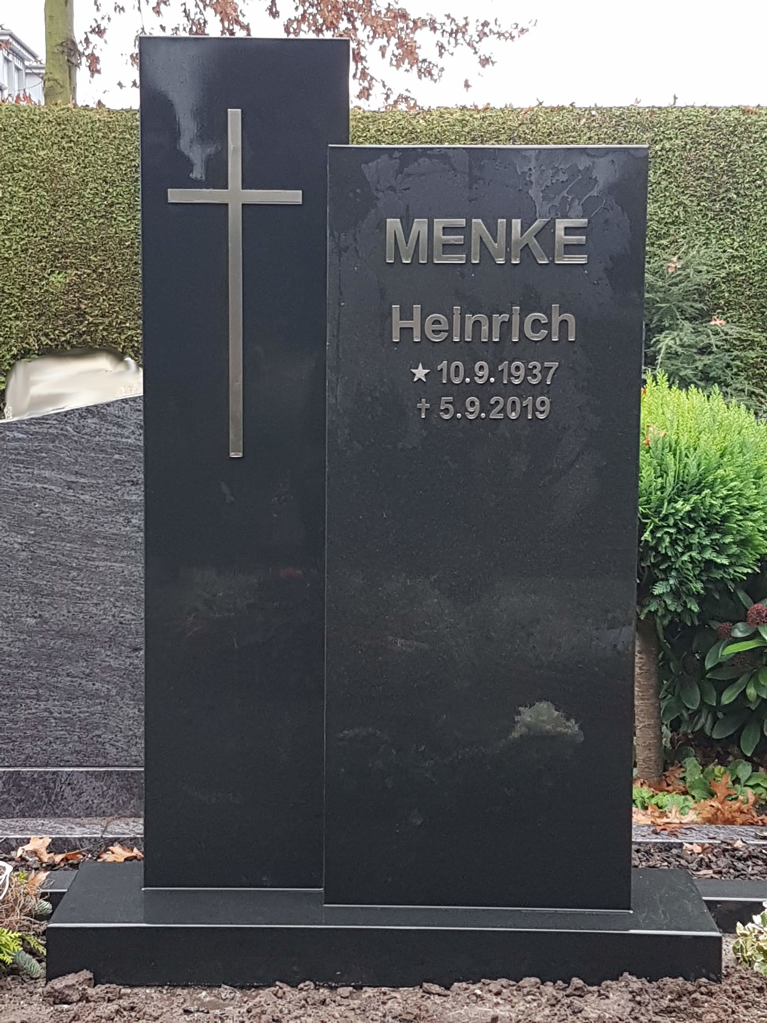 Schwarzer Grabstein für Heinrich Menke mit silbernem Kreuz und eingravierten Daten